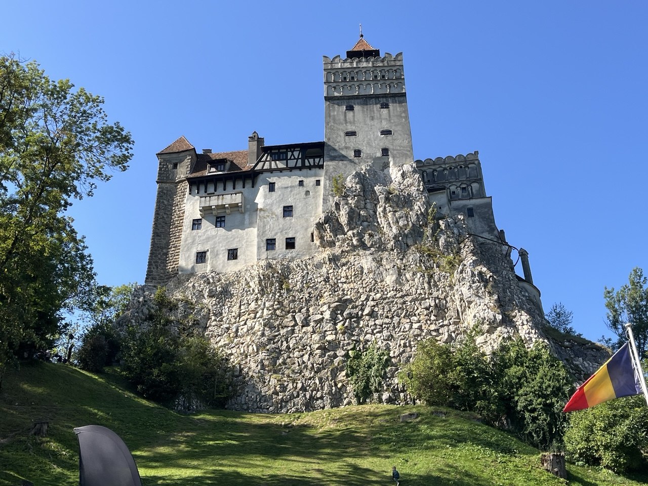 Bran Castle on a rock above a green hill