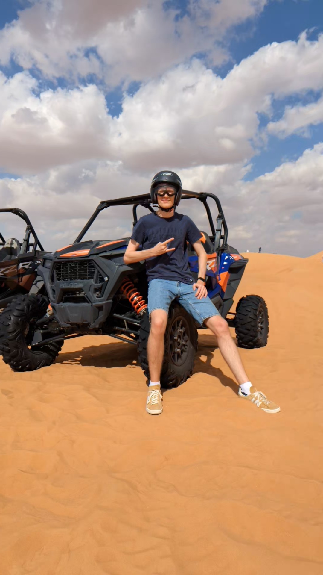 Leaning on a dune buggy in the desert